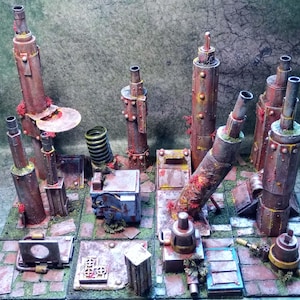 May include: A miniature, weathered, industrial-themed diorama featuring several cylindrical structures of varying heights. The structures are primarily shades of brown and rust, with red and green accents. The base is a tiled surface.