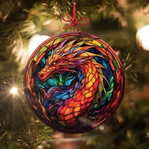 May include: A round Christmas ornament featuring a colorful stained glass dragon with red, orange, yellow, blue, and green hues. The dragon's head is facing the left side of the ornament.