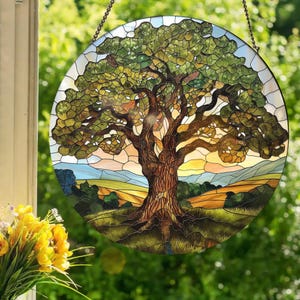 May include: A stained glass window depicting a large oak tree with a brown trunk and green leaves. The tree is set against a background of rolling hills and a sunset sky.