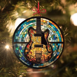 May include: A stained glass Christmas bauble shaped like a guitar. The guitar is decorated with a mosaic of colourful glass pieces, including shades of blue, green, yellow, orange, and red. The bauble is hanging from a red ribbon.