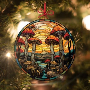 May include: A stained glass bauble depicting a whimsical scene of mushrooms in a woodland setting. The bauble is circular and features a vibrant sunset with a blue lake in the foreground. The mushrooms are red and white with yellow stems.