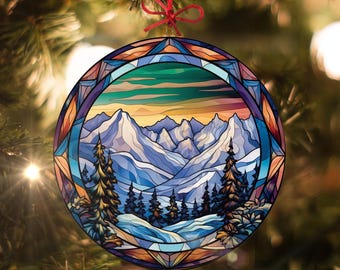 May include: A round Christmas ornament with a stained glass design of a snowy mountain landscape. The ornament features a blue, purple, and green color scheme with a sunset in the background.