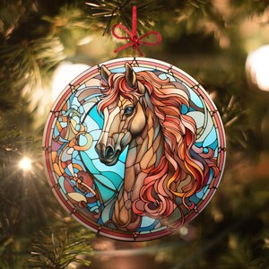 Pode incluir: Um ornamento de vidro colorido com a cabeça de um cavalo com uma crina vermelha, laranja e marrom sobre um fundo azul e verde.