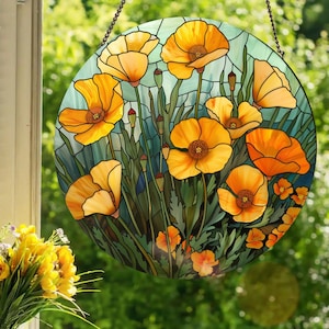 May include: A stained glass window panel featuring a circular design of yellow poppies with green leaves and stems on a blue background.