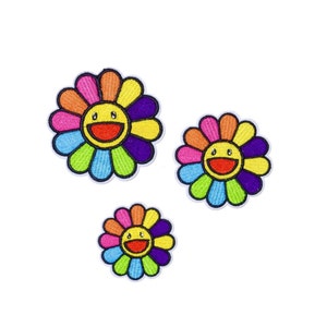 May include: Three embroidered iron-on patches in the shape of a colourful flower with a smiling face. The patches are in different sizes.