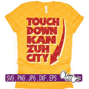 Op de afbeelding: Een gele t-shirt met de tekst "TOUCH DOWN KAN ZUH CITY" in rode blokletters. Aan de rechterkant is een wit en rood pijldesign te zien. Onderaan het shirt staat een paarse banner met bestandsextensies.