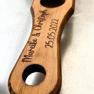 Pode incluir: Uma bandeja de servir de madeira com tr&ecirc;s recortes redondos. A bandeja &eacute; gravada com o texto "Mareike & Christoph 25.05.2022".