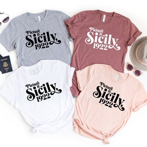 May include: Four t-shirts with the text "Picture it... Sicily 1922" in a retro font. The shirts are in gray, maroon, white, and pink.