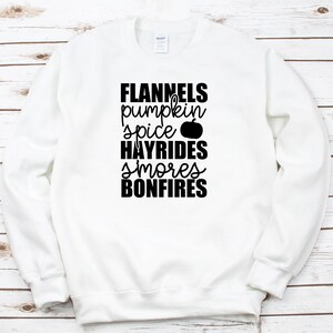 May include: White sweatshirt with black text that reads "Flannels pumpkin spice HAYRIDES smores BONFIRES" with a small pumpkin graphic.