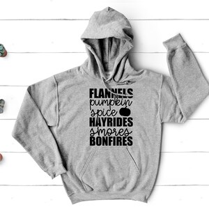 May include: A grey hooded sweatshirt with the text "FLANNELS pumpkin spice HAYRIDES smores BONFIRES" printed in black.