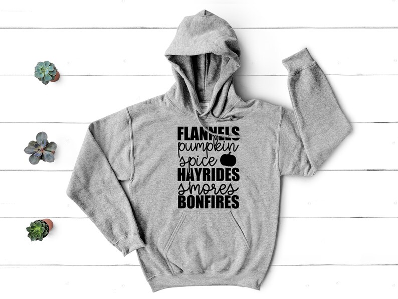 May include: A grey hooded sweatshirt with the text "FLANNELS pumpkin spice HAYRIDES smores BONFIRES" printed in black.