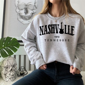 May include: Gray sweatshirt with black text that reads "NASHVILLE 1972 TENNESSEE" with a guitar graphic.