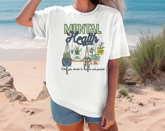 May include: White t-shirt featuring a graphic of hanging plants and the text "Mental Health" and "What you decide to nurture will flourish".