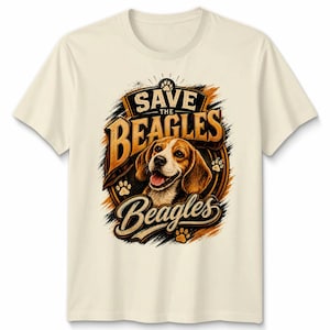 May include: A cream-coloured t-shirt with a beagle dog graphic and the text "Save the Beagles." The design includes paw prints and a circular emblem with the dog's face. The shirt is made of a soft material.