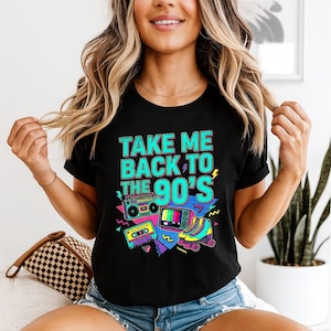 May include: Black t-shirt featuring a vibrant 90s design. The shirt displays the text "TAKE ME BACK TO THE 90'S" alongside illustrations of a boombox, TV, cassette tape, and roller skates.