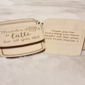 May include: Two wooden coffee cup shaped signs with a thank you message. The first sign says "Thanks a latte for all you do!" with a small heart inside the cup. The second sign says "Thank you for everything you have taught me this year, Love From Darcie x".