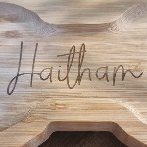 May include: A light brown wooden serving tray with the name "Haitham" engraved on the surface.