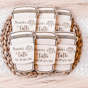 May include: Six wooden coffee cup sleeves with the text "Thanks a latte for all you do!" and a small heart graphic.