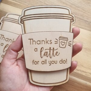 May include: Wooden coffee cup sleeve with the text "Thanks a latte for all you do!" and a small coffee cup icon with a heart.