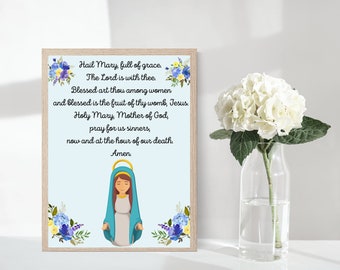 May include: A printable digital download of a religious prayer to the Virgin Mary. The prayer is written in black text on a light blue background with a floral border. The image includes a cartoon illustration of the Virgin Mary.