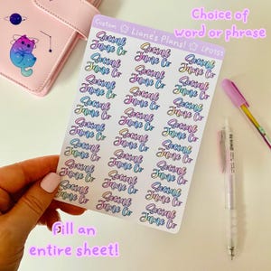 Può includere: Un foglio di adesivi con le parole "Social Jane Co" ripetute più volte in un gradiente arcobaleno. Gli adesivi sono su uno sfondo bianco e sono pronti per essere utilizzati per riempire un foglio intero.