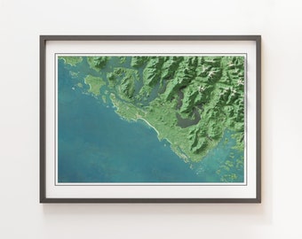 May include: A framed aerial photograph of a coastal landscape. The image shows a green, mountainous area with a coastline that extends into a blue body of water. The water is a light blue color and the mountains are a dark green color.