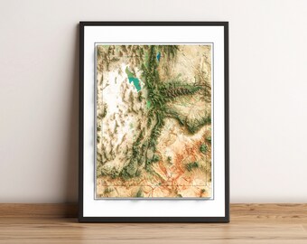 May include: A framed topographic map of Utah, showing the state's varied terrain in shades of green, brown, and beige. The map is framed in a black frame with a white mat.