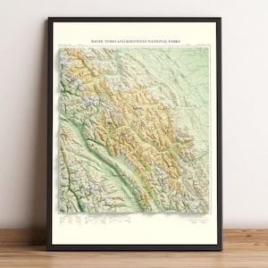 May include: Framed topographic map of Banff, Yoho, and Kootenay National Parks. The map features a detailed relief, with shades of green, brown, and tan indicating elevation changes. The title "BANFF, YOHO AND KOOTENAY NATIONAL PARKS" is printed at the top.