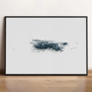 May include: Framed art print featuring a 3D topographical map of Puerto Rico in shades of blue and white. The artwork is set against a white background within a black frame, displayed on a wooden surface.