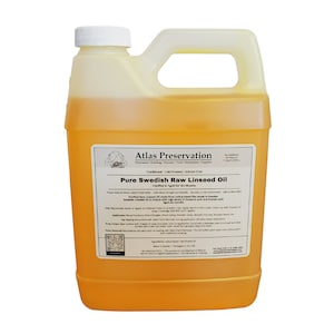 May include: A gallon jug of Atlas Preservation Pure Swedish Raw Linseed Oil. The label is yellow with black text and a logo of a person holding a paintbrush. The oil is a light yellow color.
