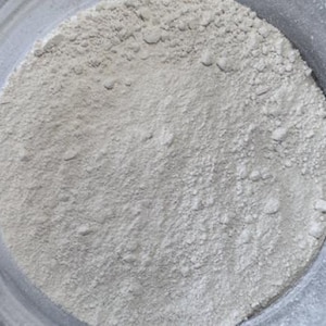 May include: A close-up view of a white powder in a bowl. The powder is fine and smooth, and it appears to be evenly distributed throughout the bowl.
