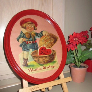 May include: Oval red framed Valentine's Day greeting on a wooden easel. The image features a vintage illustration of a child holding a walnut with a heart that says "I Love You". The text "All in a Nutshell" and "Valentine Greeting" are also visible.