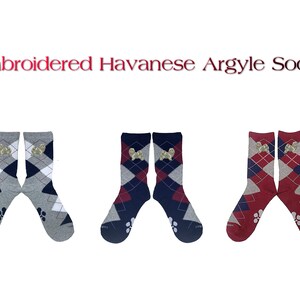 May include: Three pairs of argyle socks with embroidered Havanese dog images. The socks are in grey and white, navy and white, and red and white.