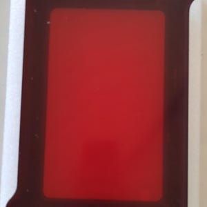 May include: A red screen printing frame with black handles and a white background.