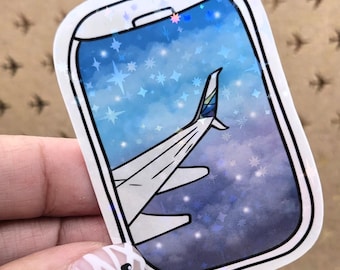 May include: A sticker featuring a stylized airplane wing viewed through a window against a starry sky. The window frame is white with a black outline. The sky transitions from blue to purple, with white stars.
