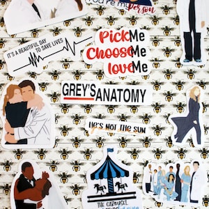 May include: A collection of stickers featuring characters and quotes from the television show Grey's Anatomy. The stickers include phrases like "Pick Me, Choose Me, Love Me" and "It's a beautiful day to save lives."