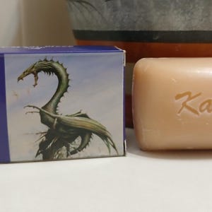 May include: A blue box with a dragon illustration and the text "Dragons Blood Soap" next to a bar of soap with the text "Kamini" on it.