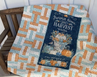May include: A blue and orange patchwork quilt with a fall-themed design featuring pumpkins, a bird, and the text "Pumpkin Kisses and Harvest Wishes".
