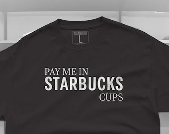 May include: Black t-shirt with white text that reads "Pay me in Starbucks Cups".