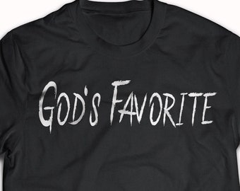May include: Black t-shirt with the text "God's Favorite" printed in white on the front.