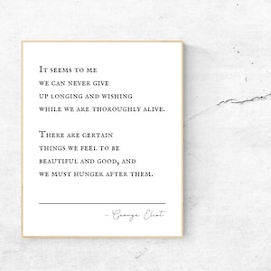 May include: Black and white typography print with a quote by George Eliot: "It seems to me we can never give up longing and wishing while we are thoroughly alive. There are certain things we feel to be beautiful and good, and we must hunger after them."