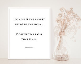 May include: A white framed print with a black and white quote by Oscar Wilde: "To live is the rarest thing in the world. Most people exist, that is all."