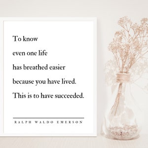 Op de afbeelding: Een wit ingelijst print met een citaat van Ralph Waldo Emerson: "Om te weten dat zelfs &eacute;&eacute;n leven gemakkelijker heeft geademd omdat je hebt geleefd. Dat is succesvol zijn."