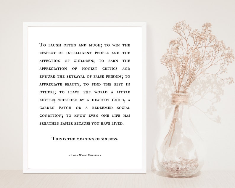 Puede incluir: Una impresi&oacute;n en blanco y negro con una cita de Ralph Waldo Emerson sobre el significado del &eacute;xito. La cita est&aacute; impresa en un fondo blanco y enmarcada en un marco blanco. La impresi&oacute;n est&aacute; sobre una mesa junto a un jarr&oacute;n de flores secas.
