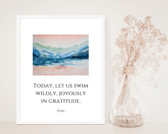 Puede incluir: Una pintura de acuarela de una cordillera reflejada en un lago. El cielo es de un rosa y naranja suave. La cita "TODAY, LET US SWIM WILDLY, JOYFULLY IN GRATITUDE. -RUMI- " está impresa debajo de la pintura.