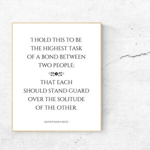 May include: A black and white printable quote by Rainer Maria Rilke about the highest task of a bond between two people. The quote reads: "I hold this to be the highest task of a bond between two people: That each should stand guard over the solitude of the other."