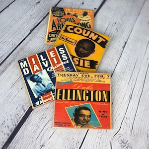 Op de afbeelding: Vier vierkante onderzetters met vintage jazz concertposters van Louis Armstrong, Count Basie, Miles Davis en Duke Ellington. Elke onderzetter toont gedurfde typografie, zwart-witportretten van de muzikanten en kleurrijke achtergronden.