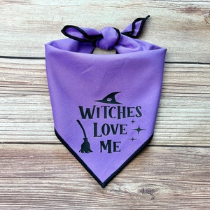 May include: Purple dog bandana with black trim and the text "Witches Love Me" with a witch's hat and broom graphic.