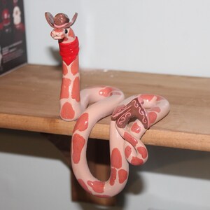 May include: A set of three ceramic mugs with a speckled, matte finish. The mugs are in shades of cream, light grey, and dark grey. Each mug has a simple, minimalist design and a rounded handle. Suitable for coffee, tea, or other beverages.