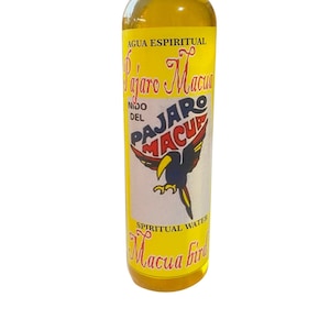 May include: A yellow bottle of "Agua Espiritual Pajaro Macua" spiritual water. The bottle has a white cap and a label with a black and red toucan illustration. The label also says "Nido del Pajaro Macua" and "Spiritual Water Macua Bird".